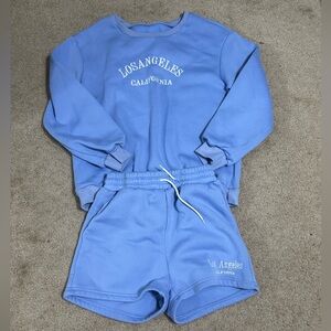 blue embroidered sweatshirt and shorts.